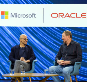 Satya Nadella and Larry Ellison seated on stage, with the logos of Microsoft and Oracle behind them