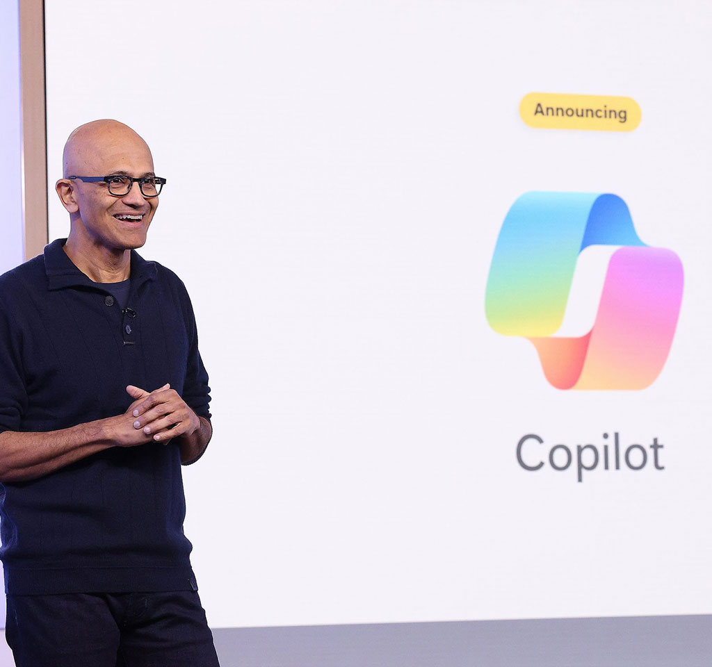 Satya Nadella onstage withe the Copilot logo behind him