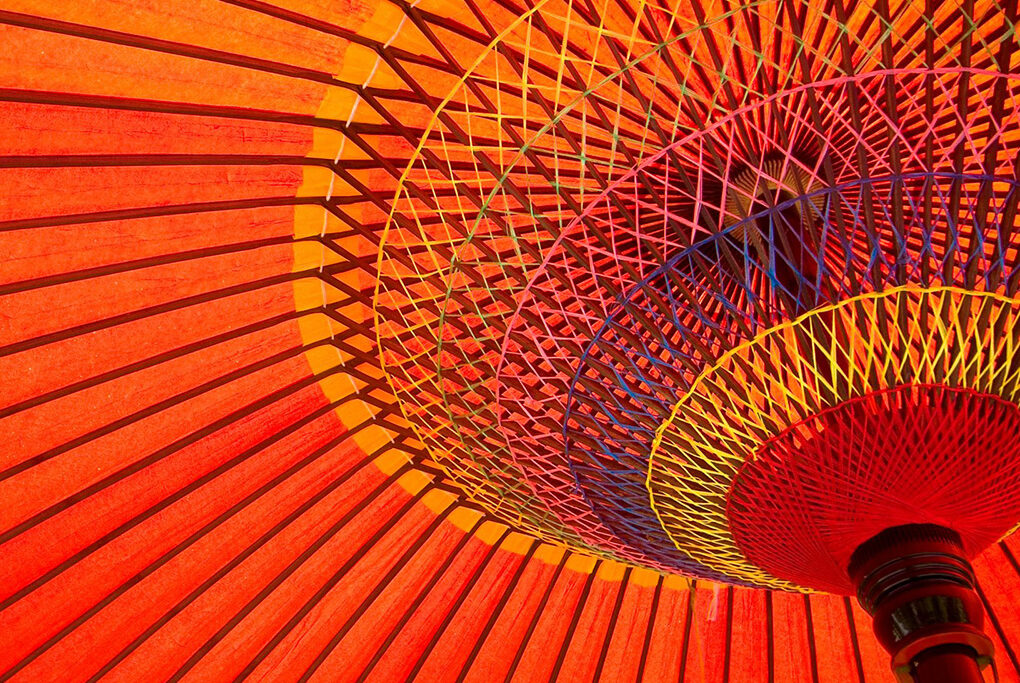 View looking up at an open, orange Japanese umbrella