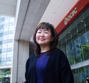 Woman standing in front of an OCBC Bank branch