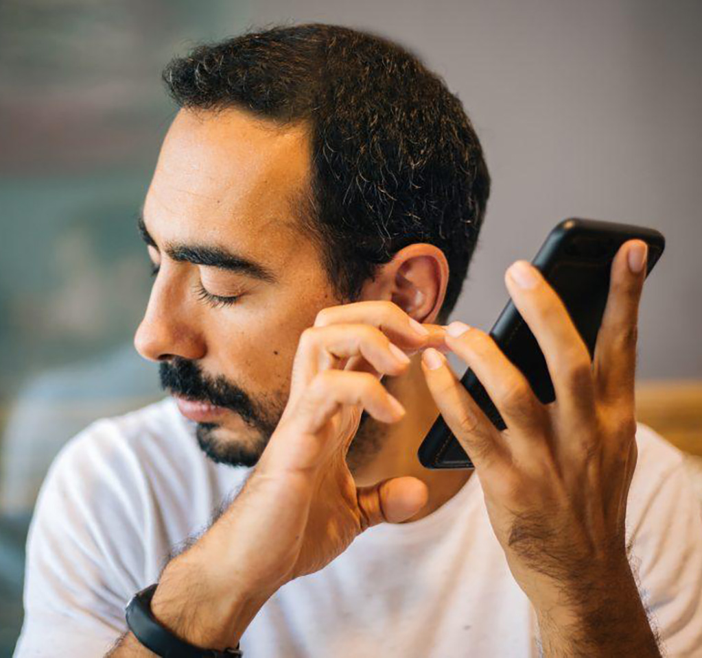 Man facing away from phone as he interacts with it using his fingers