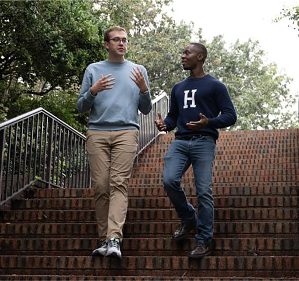 Two men walk down outside stairs