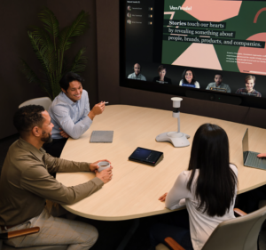 Three people in an office meet over Teams with five people attending remotely