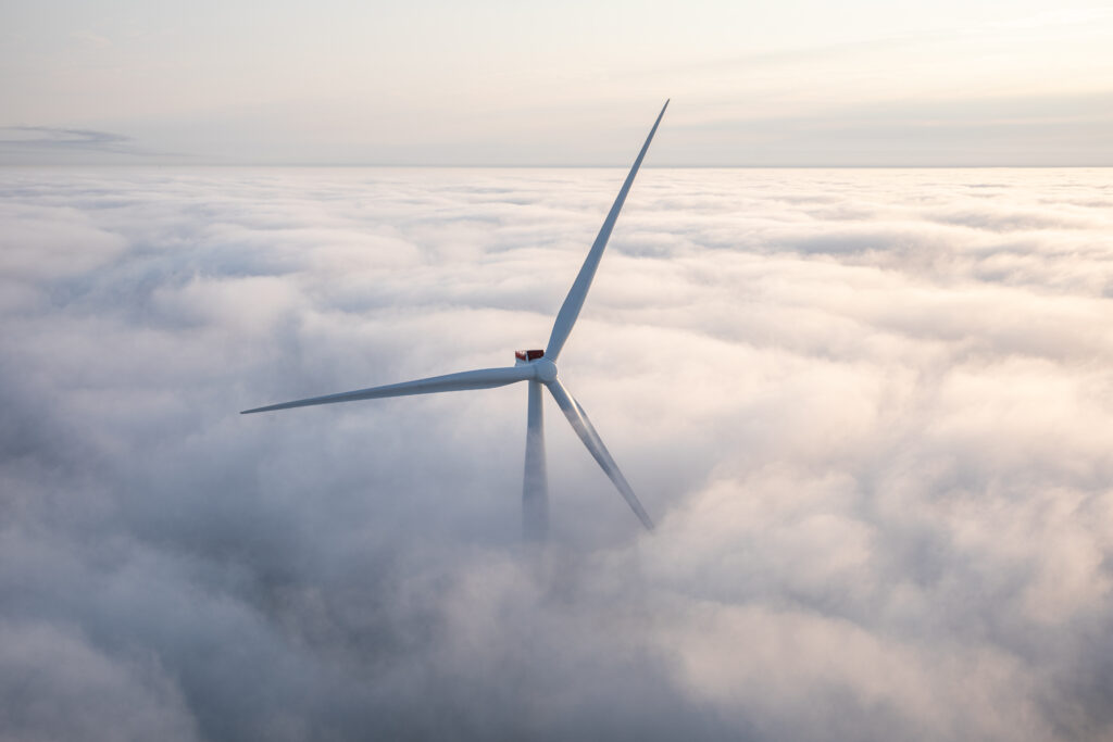 A wind turbine pokes through the clouds.