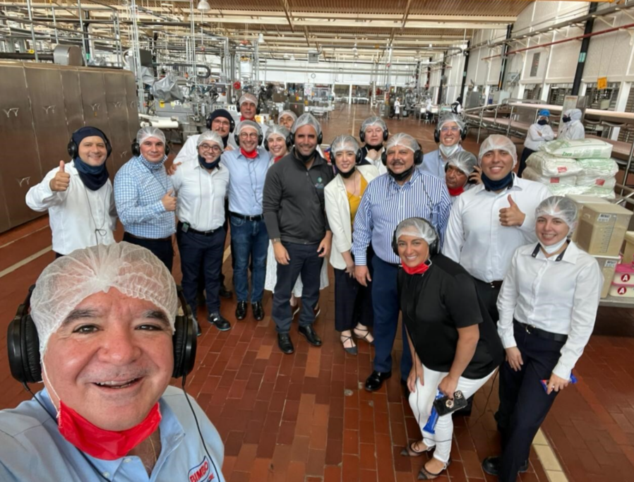 People pose for a picture inside a Grupo Bimbo bakery plant. 