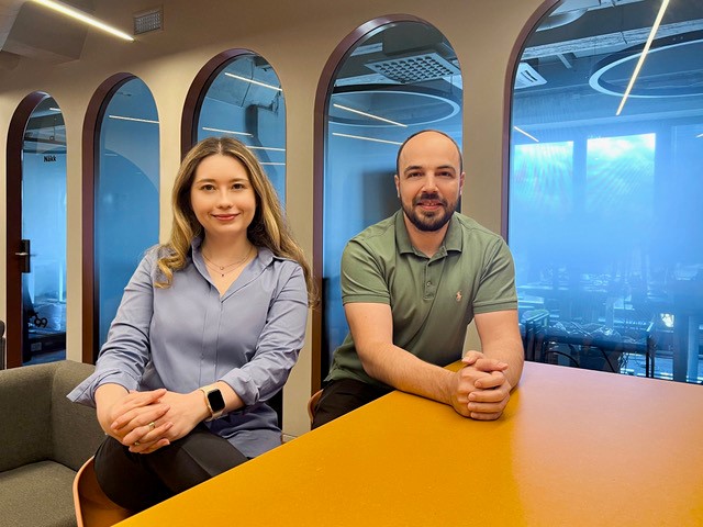 Photo of Anastasia Georgievskaya and Konstantin Kiselev, co-founders of Haut.AI, sitting at a table in an office. 