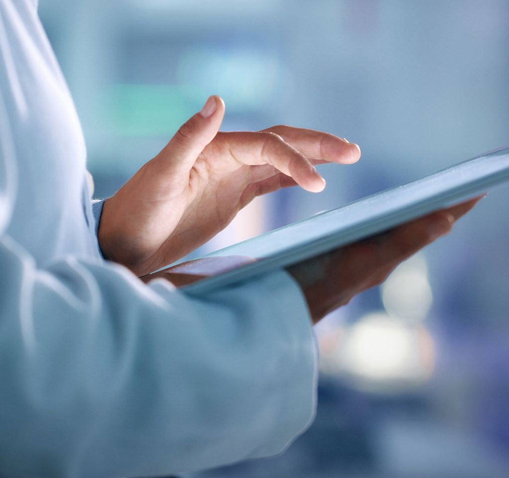 Hands of a medical professional holding a tablet device