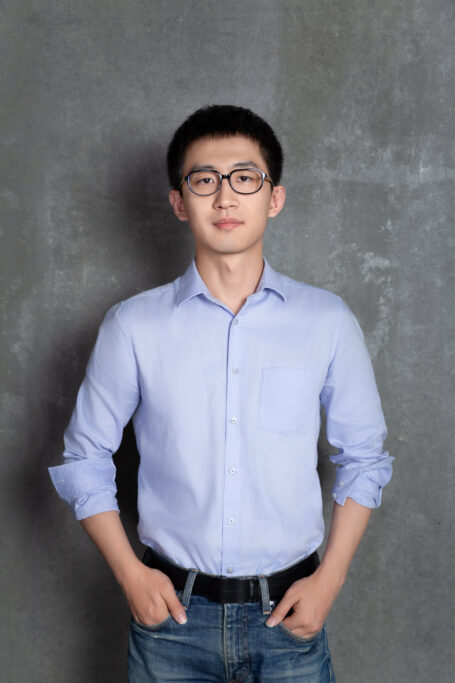 A male researcher in a blue shirt and jeans.