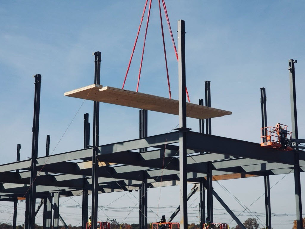 Image of a sheet of timber being placed in the datacenter under construction.