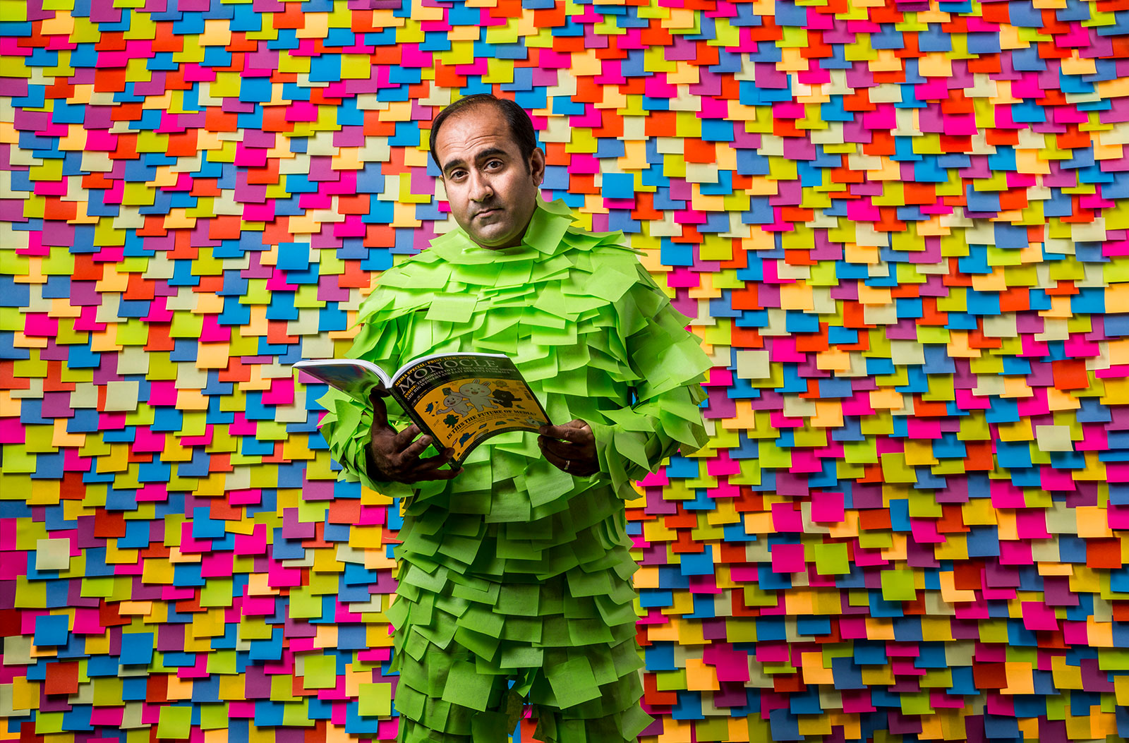 Rohit reading a magazine in front of post-it notes.