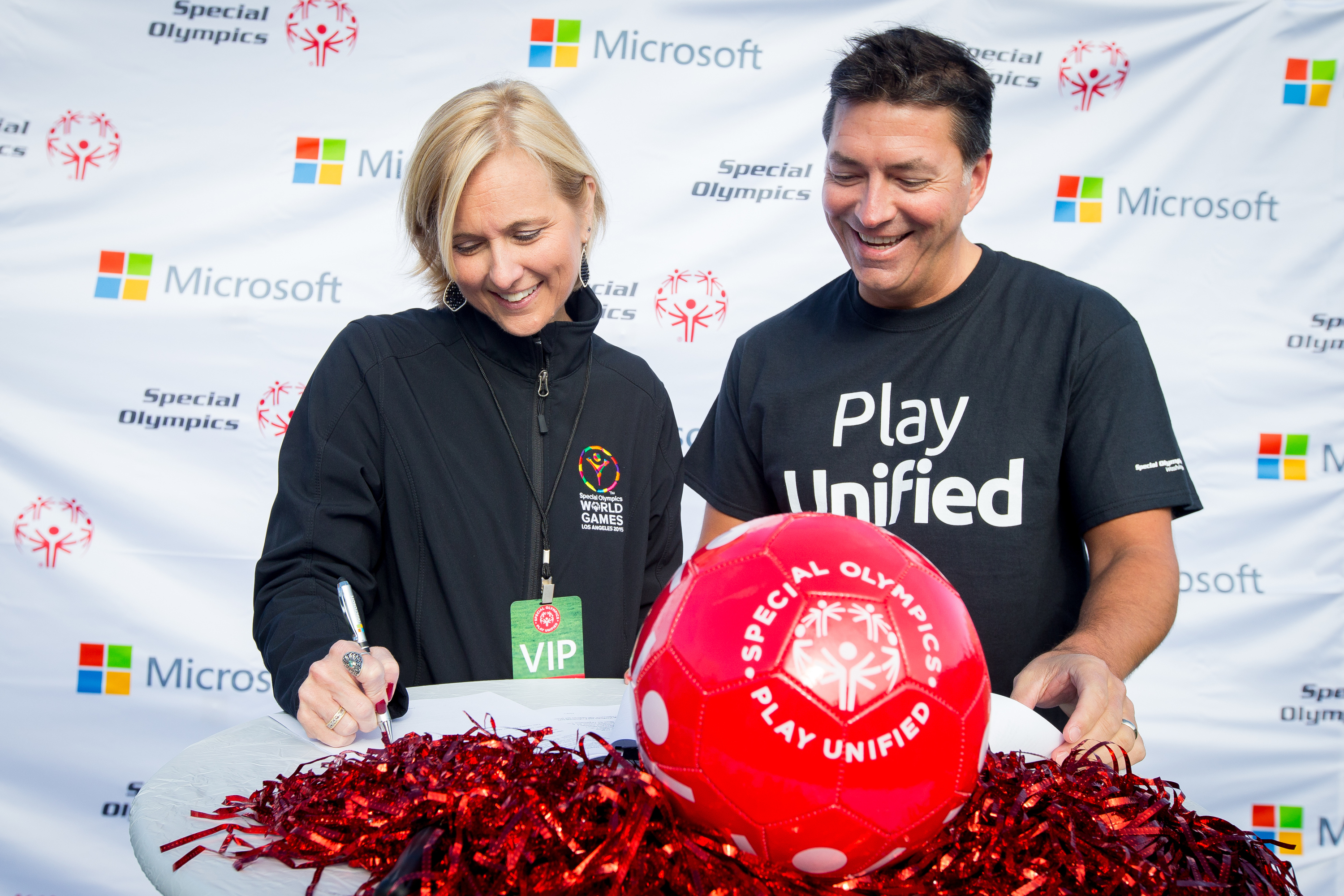 Special Olympics Chief Executive Officer Janet Froetscher and Jeff Hansen, general manager of Microsoft Brand Studio, sign the agreement 