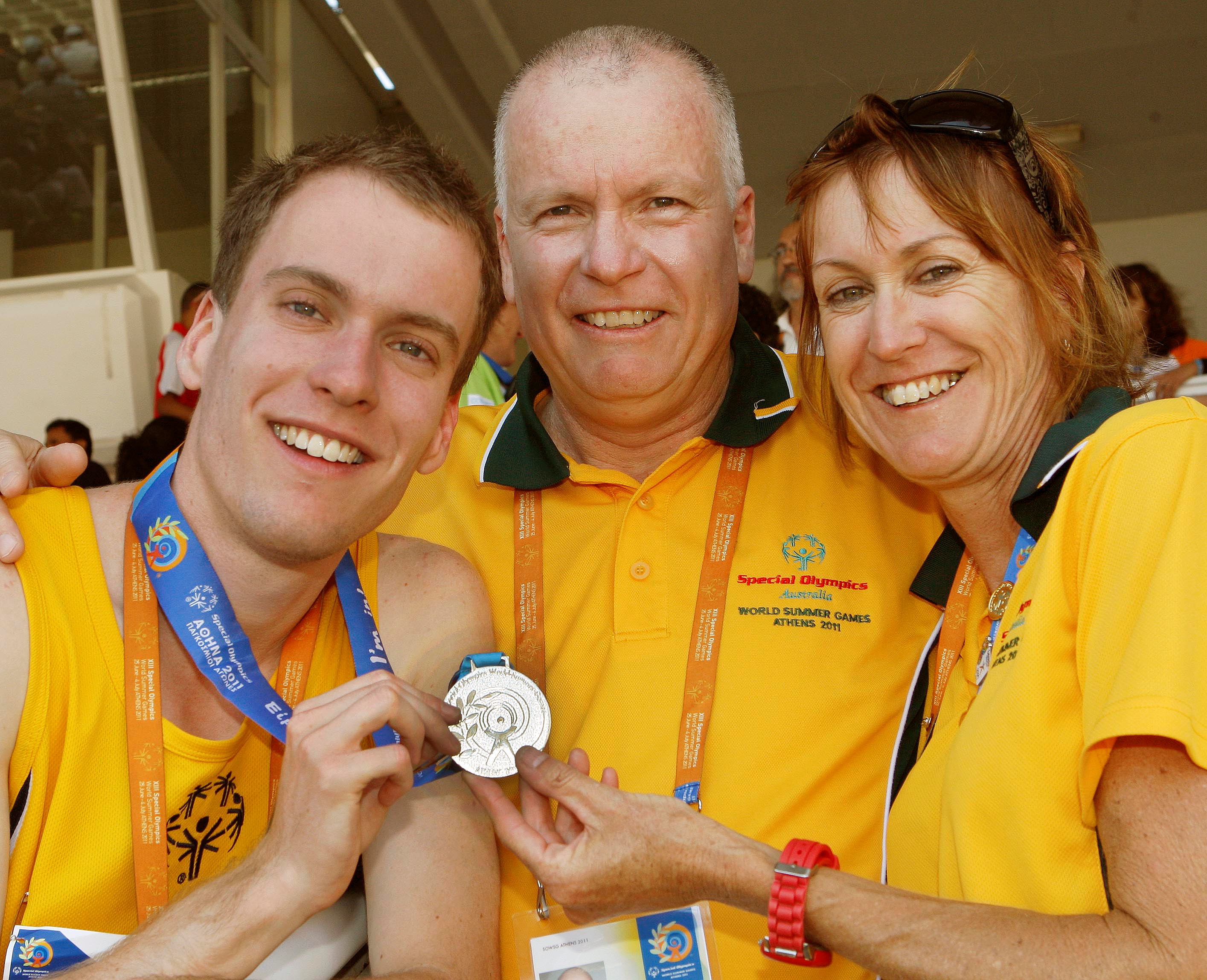 Matt Pascoe, left, displays his silver medal from the 2011 Special Olympics World Games in Athens with parents John and Tricia Pascoe. Photo courtesy of Special Olympics. 