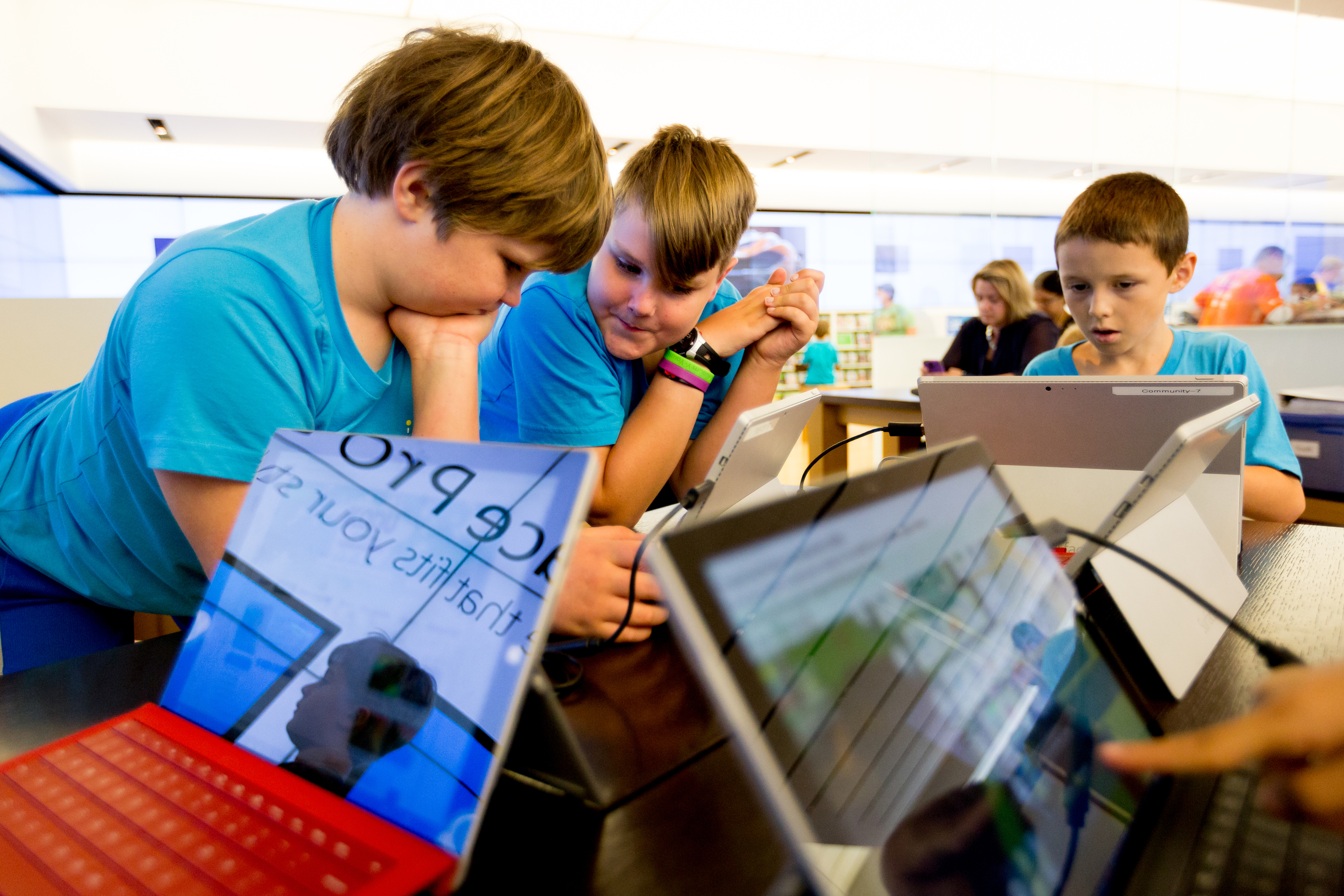 Brothers Robert Wallace, 9, left, and Charles Wallace, 11, team up as they work to learn coding, along with Kayden Barnard, 9, right, at the YouthSpark Summer Camp at Microsoft at Bellevue Square Mall in Bellevue, Washington. Photo credit: Scott Eklund, Red Box Pictures.