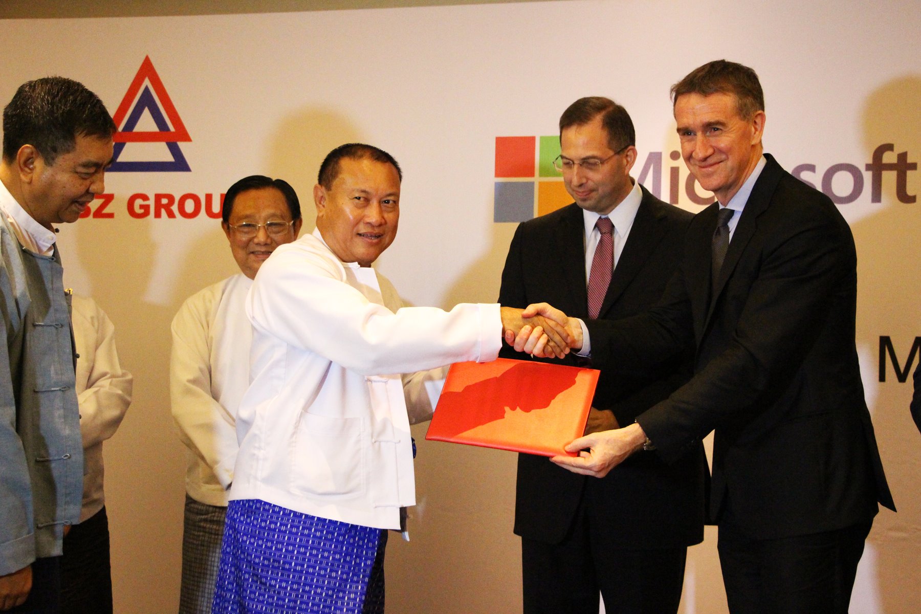 Aung Ko Win, chairman, KBZ Group of Companies exchanging the signed agreement with Bertrand Launay, vice president, Microsoft Asia. The ceremony was witnessed by Derek Mitchell, U.S. Ambassador to Burma.