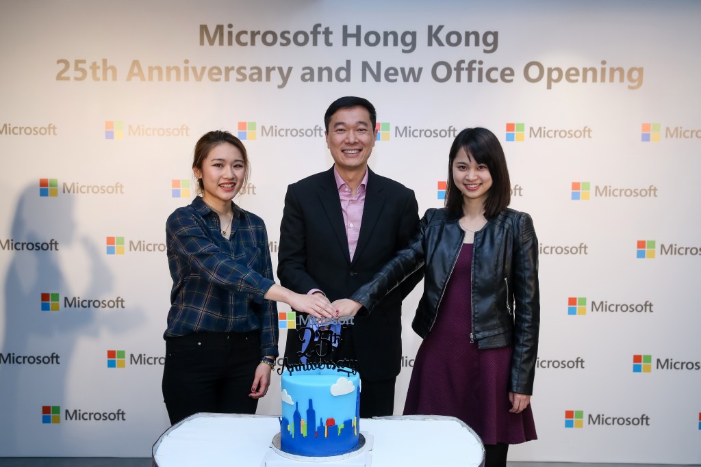 Mr. Horace Chow, General Manager of Microsoft Hong Kong cuts the cake with two staff members of an age with Microsoft Hong Kong to celebrate its 25 anniversary and new office opening.