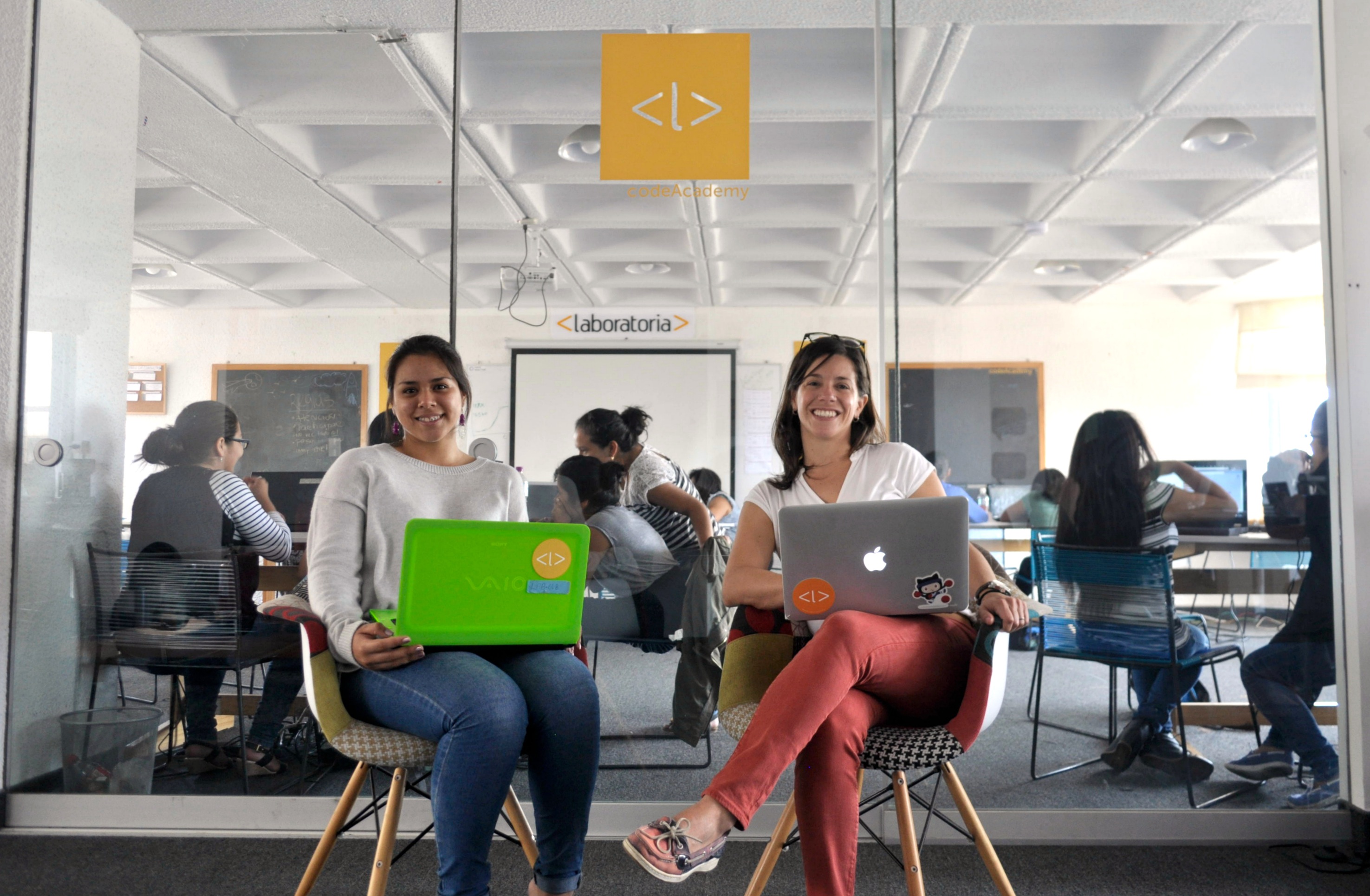 Laboratoria student Reina Torrejon poses with regional director Ana Maria Martinez in front of the Lima, Peru classroom where she and her classmates are learning front-end web development.