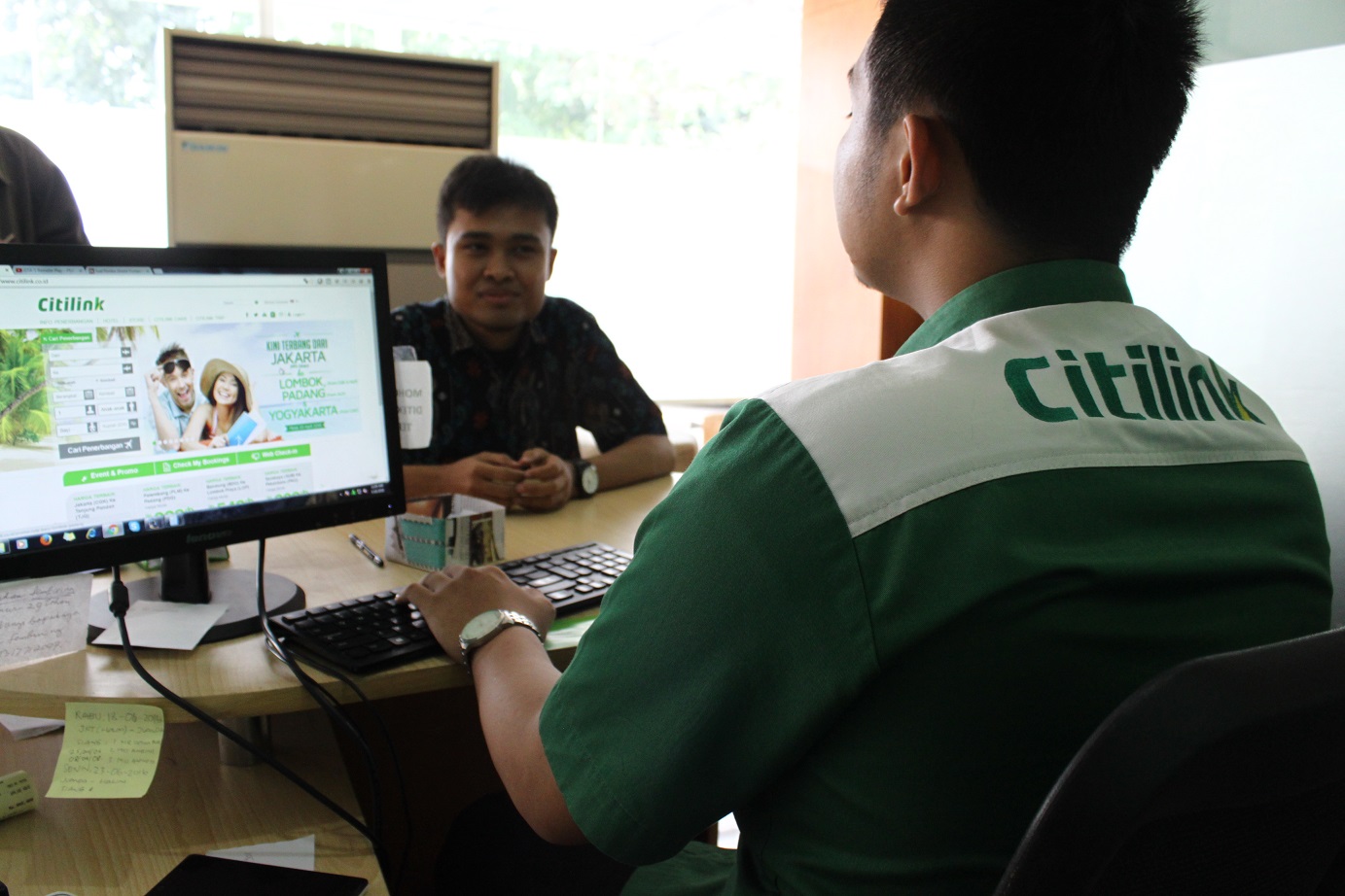 A ground staff servicing a customer at the Citilink check-in counter. Citilink ground staff now have access to data visualization tools to learn more about the customer.