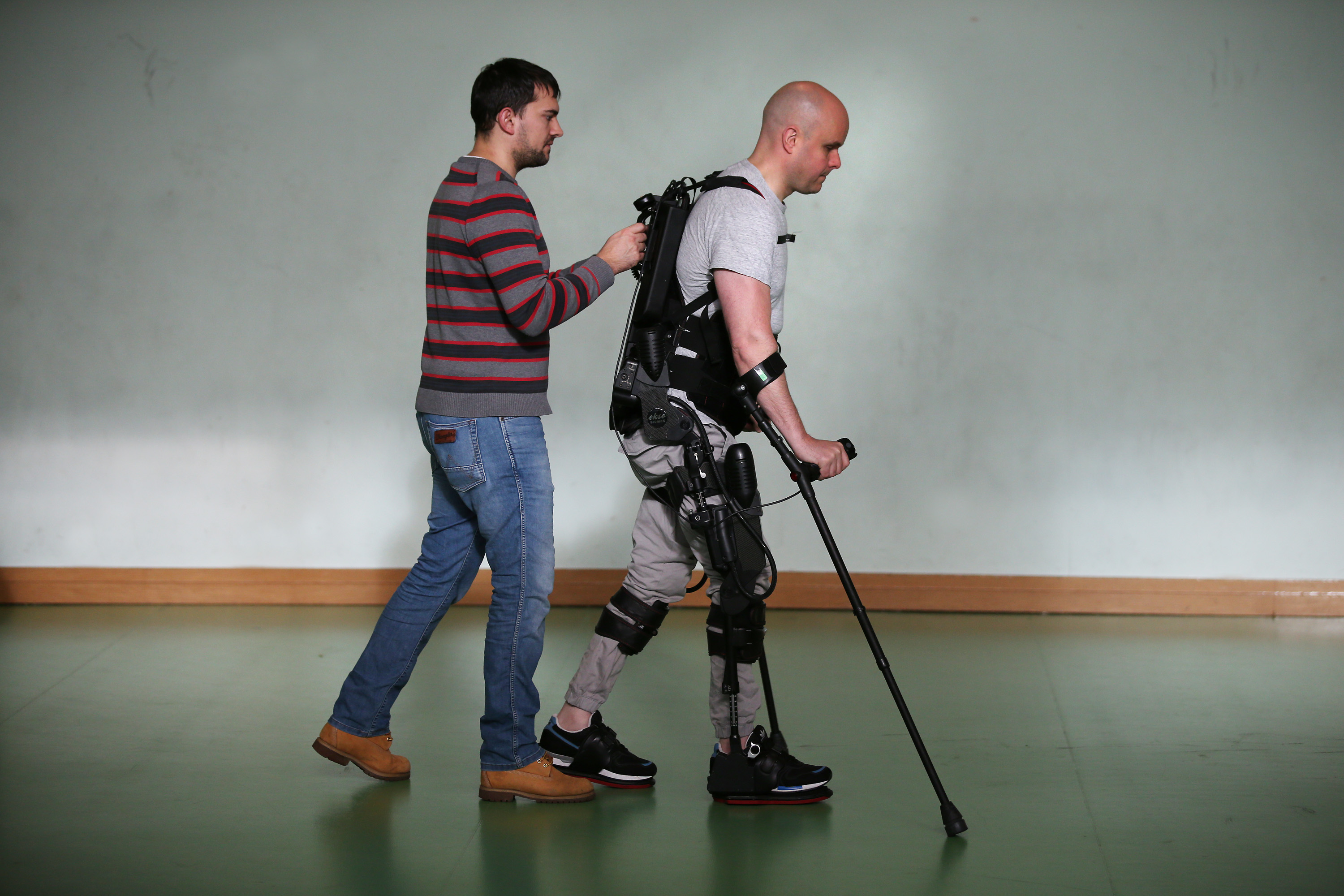 ALL IMAGES COPYRIGHT MARK POLLOCK TRUST. Mark Pollock is helped by his assistant as he walks using the Ekso Bionics robotic exoskeleton at Trinity College in Dublin 7th November 2015. Photographed by Peter Macdiarmid for the Mark Pollock Trust.