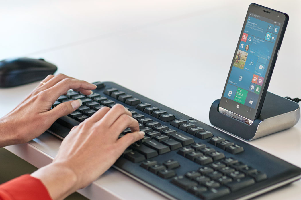A woman using an HP Elite x3 with a HP Desktop Dock at work.