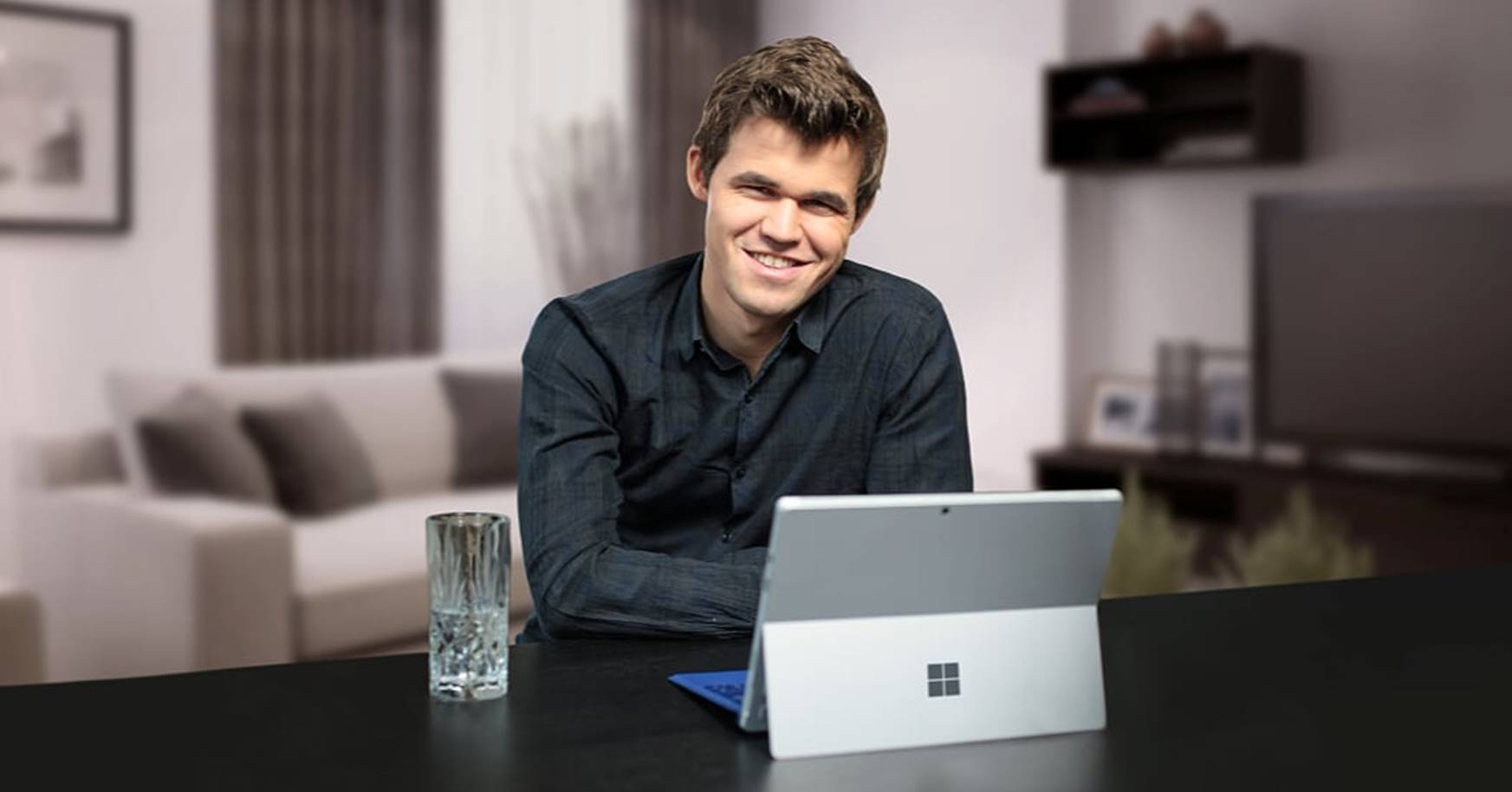 World chess champion Magnus Carlsen sitting with Surface on a table.