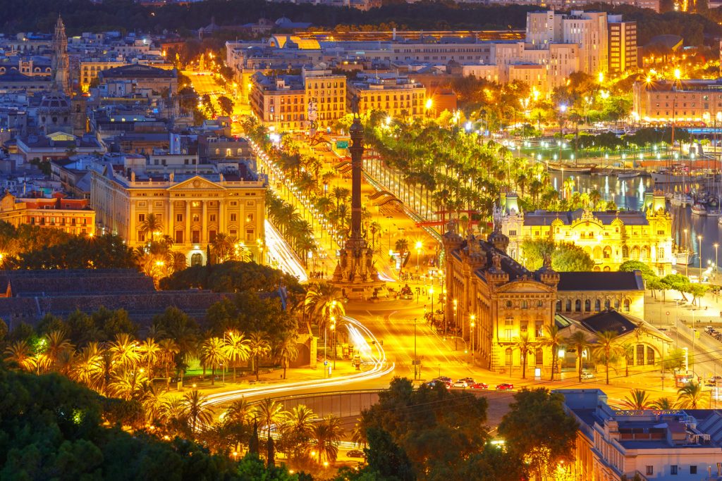 Aerial view over square Portal de la pau, and Port Vell marina and Columbus Monument at night in Barcelona, Catalonia, Spain