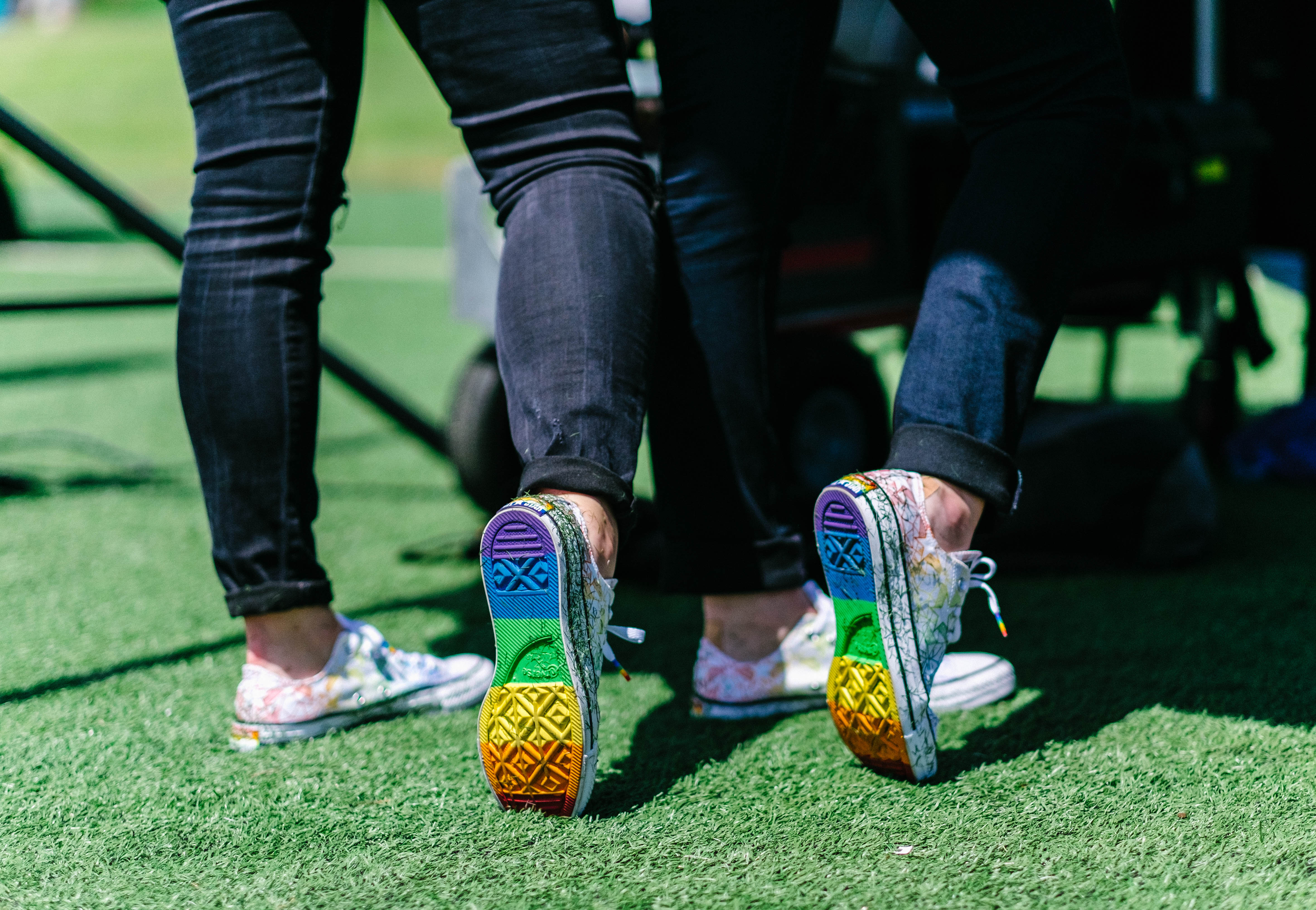 Photo of two pairs of sneakers with rainbow-striped soles