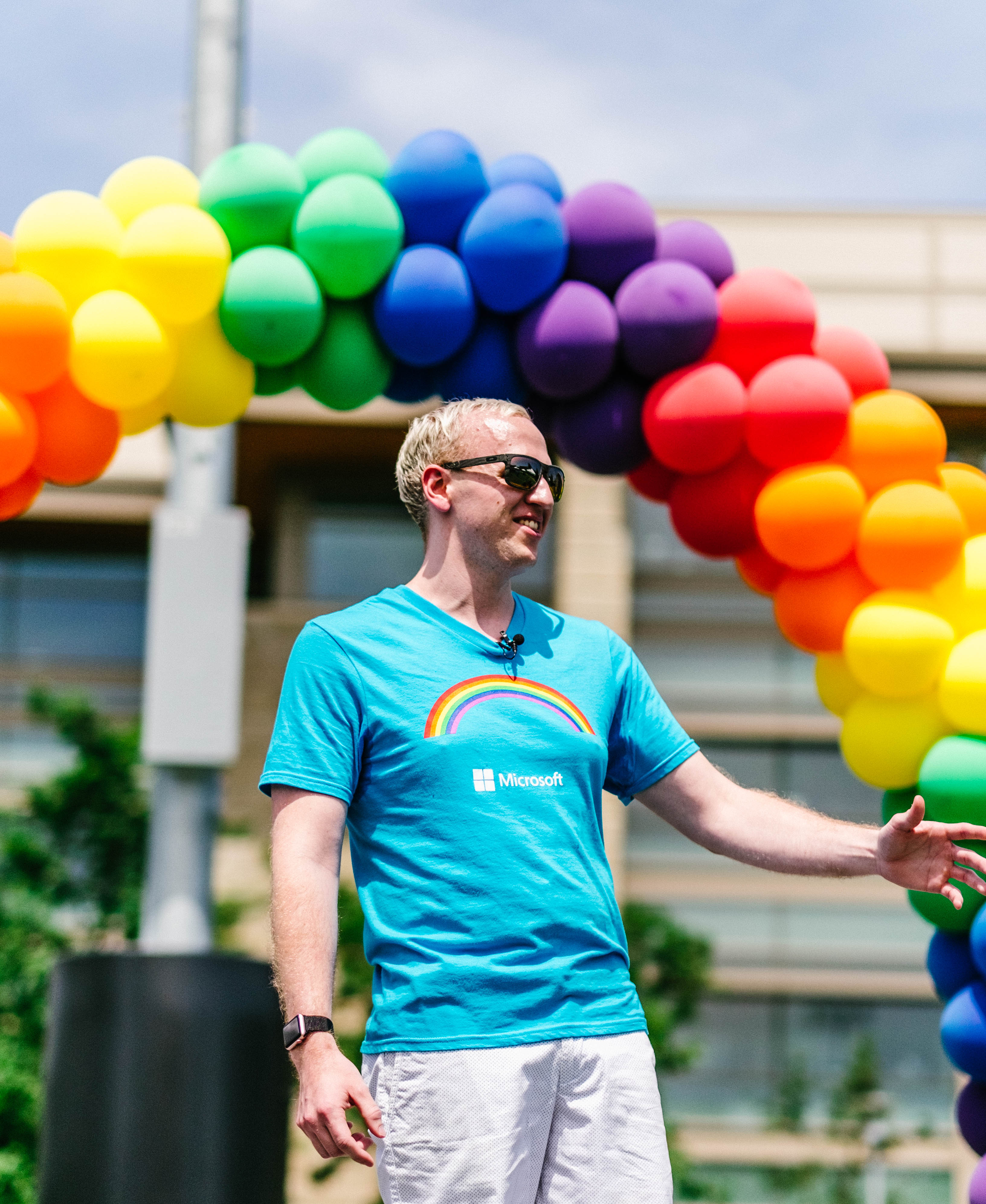 Photo of man with rainbow of balloons in background
