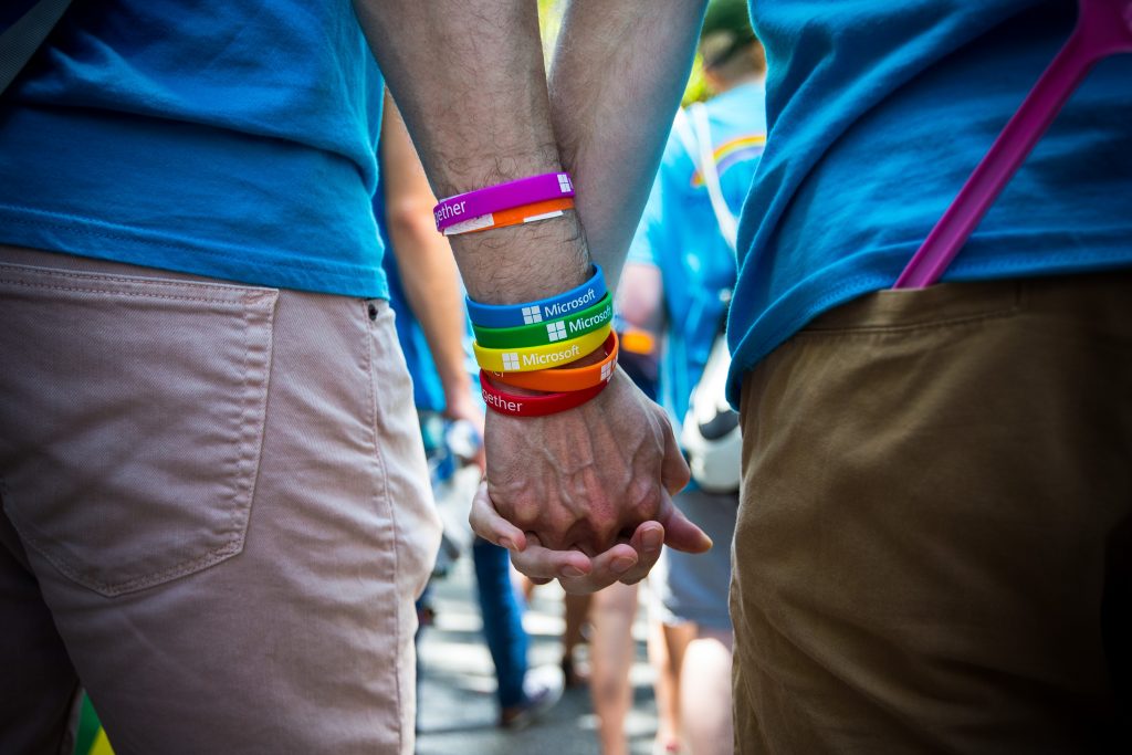Photo close-up of two people holding hands during Seattle's Pride parade