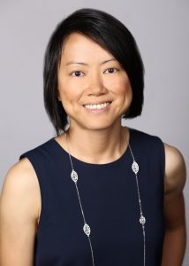 A head shot of Joy Chik, who is wearing a navy blue dress