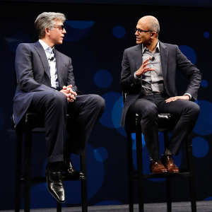 Bill McDermott and Satya Nadella sit next to each other on stools
