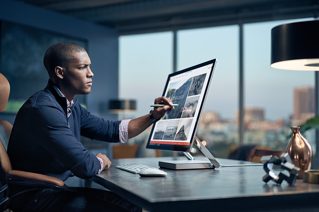 Man sitting at desk using Surface Studio