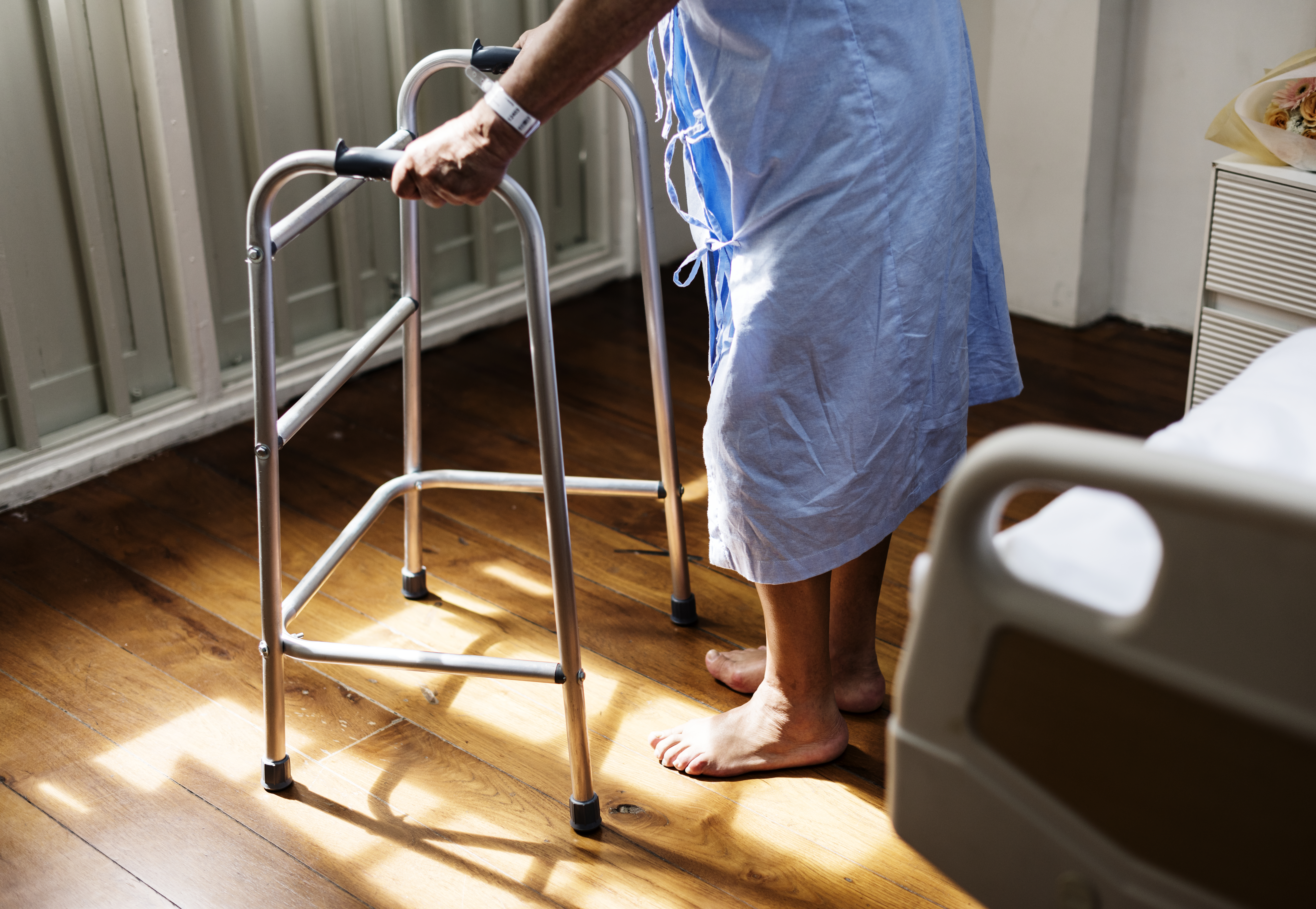 Elderly man uses walker in hospital