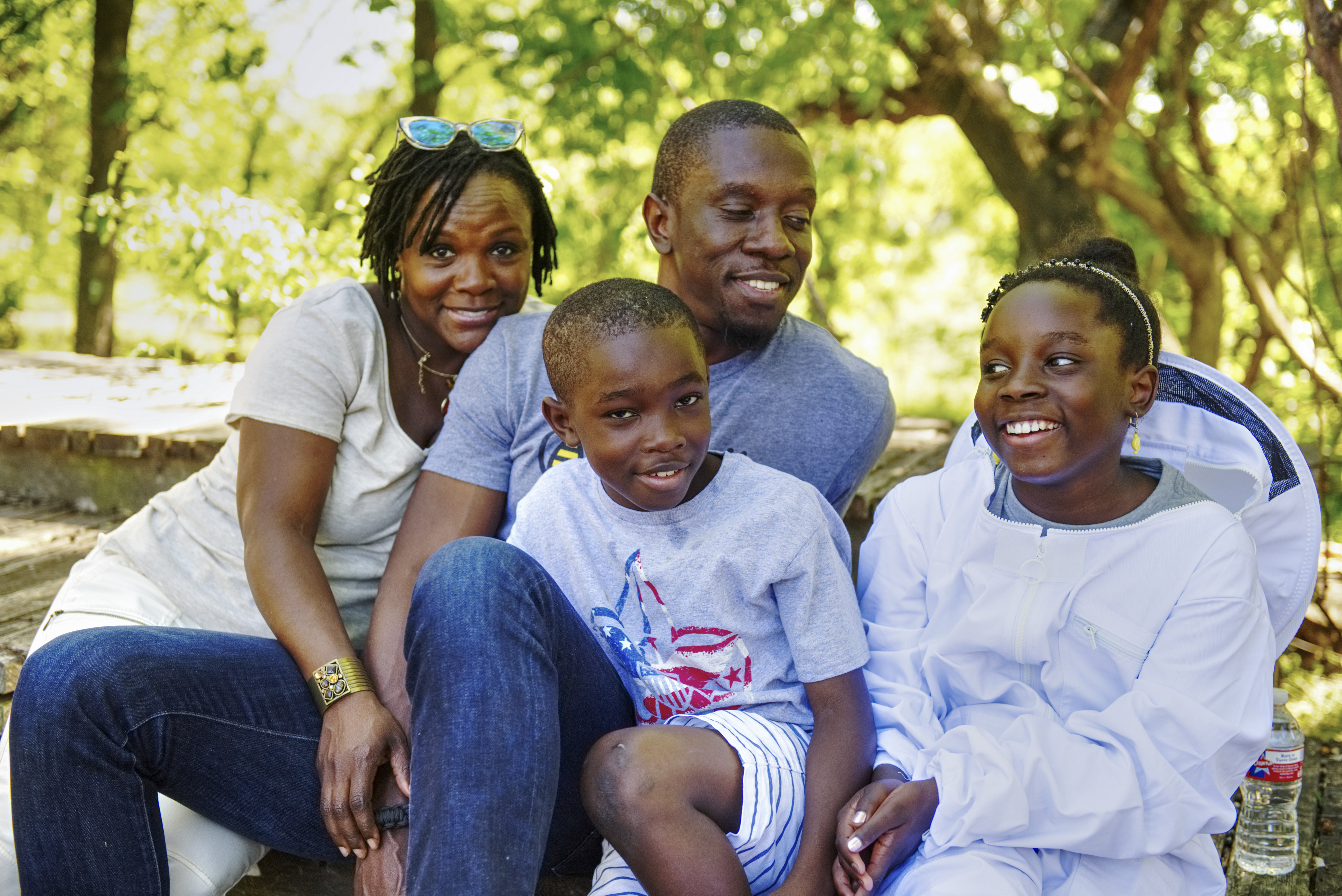 Photo of mother, father, son and daughter sitting outside