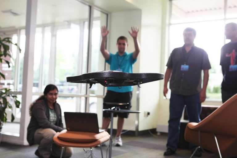 Student Alex Wiggins gestures to Kinect, which in turn makes a remote-control toy helicopter take off while teammates Ruma Paul (left) and Fabio Matsui (right) look on. The trio was one of 50 people participating in Code Camp on Wednesday on Microsoft’s Redmond Campus.