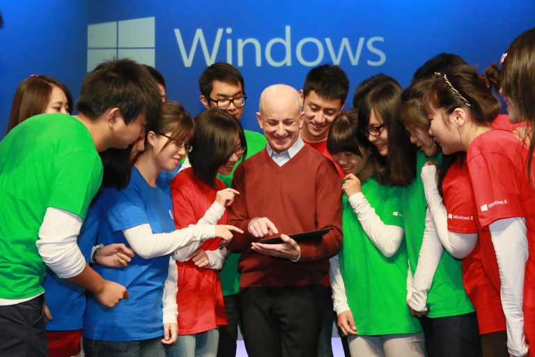 Steven Sinofsky, President of the Windows Division, is joined by excited Chinese students on stage.