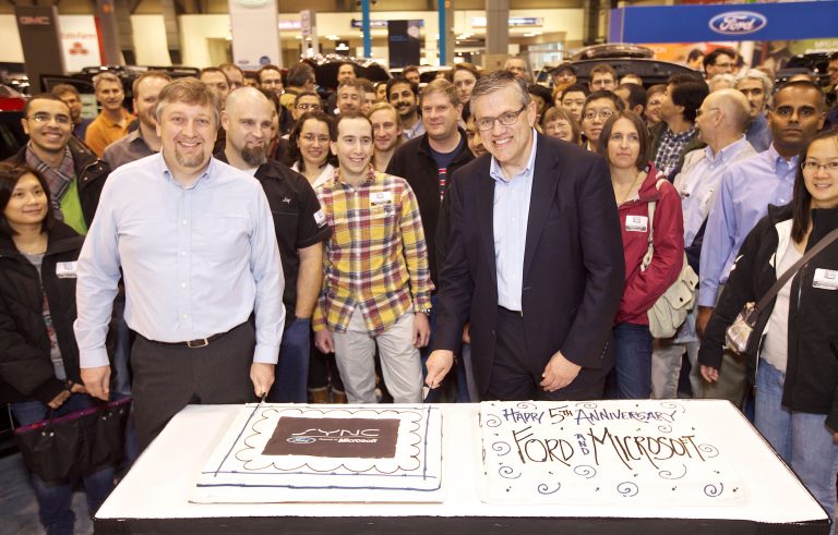 Microsoft Senior Program Manager for Windows Embedded Walter Sullivan, left, and Ford s Director of Electrical and Electronics Systems Jim Buczkowski pose during a ceremonial cake-cutting at the Ford SYNC, powered by Microsoft, Fifth Anniversary celebration during the first day of the Seattle Auto Show on Wednesday, Nov. 14, 2012 in Seattle. Microsoft and Ford are celebrating Ford SYNC in five million vehicles. Ford SYNC is an in-vehicle connectivity system that enables voice-control for mobile phones and music players using the Windows Embedded Automotive software platform.