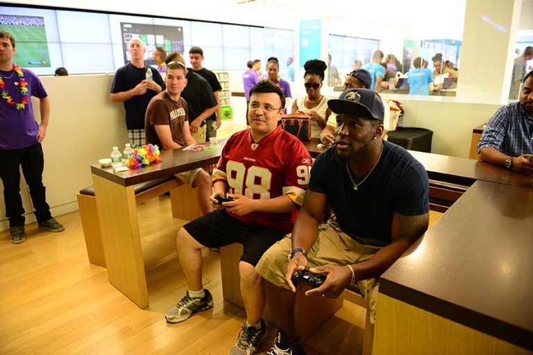 Washington linebacker Brian Orakpo plays Xbox games with a fan at The Fashion Centre at Pentagon City Microsoft Store.