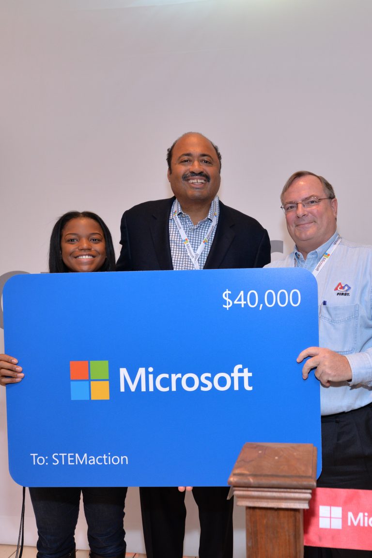STEMaction Executive Director Bill Duncan receives a technology grant from Microsoft Stores on behalf of the local community organization at the grand opening of Microsoft at Westfield Montgomery Mall on Saturday, Nov. 22, 2014.