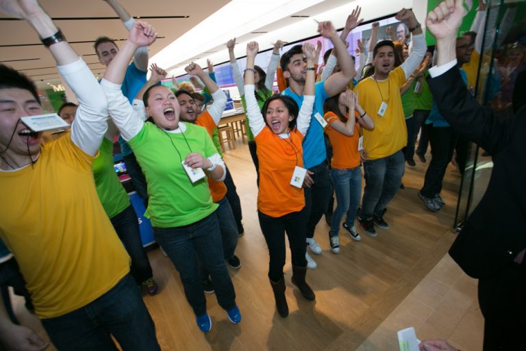 After the curtain drops, Microsoft associates welcome the first customers into the store at the grand opening of the new Microsoft retail store at Square One Shopping Centre in Mississauga, Ontario, on Feb. 8, 2014.