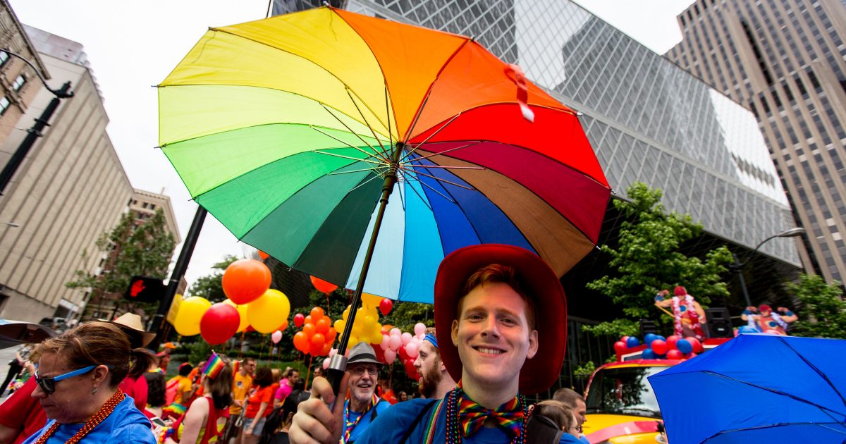 Microsoft employee Terrence Anderson carries a rainbow umbrella in the Pride Parade.