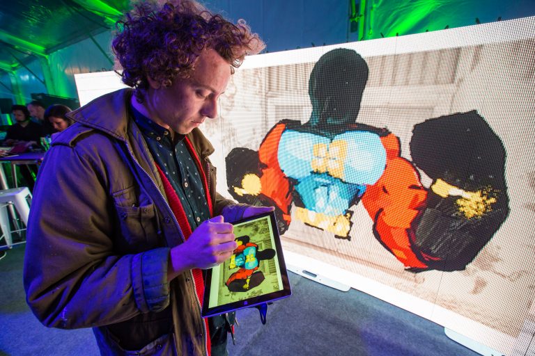 Anthony Lister projecting art to LED from Surface Pro 3 at Windows 10 fan celebration in Sydney, Australia.