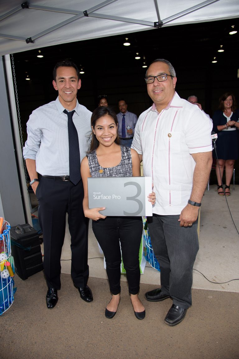 Yusuf Mehdi, corporate vice president of Windows and Devices, and Passaic, NJ Mayor Alex Blanco upgrade a deserving student