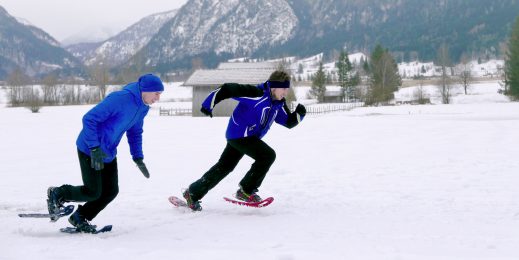Photo of Anton Grotz and Daniele Bruno racing across a snowy farm with mountains in the background