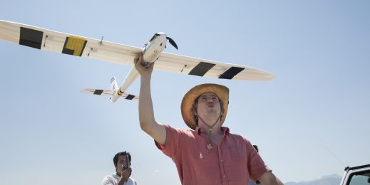 a man holds a glider, ready to launch it