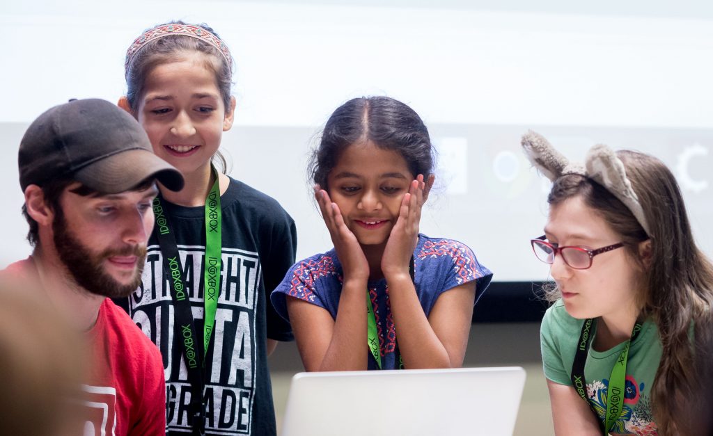 Participants at Girls Make Games camp gathered around a laptop