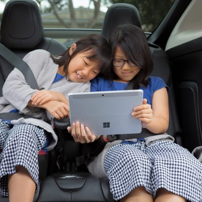 Two girls use Surface Go Lifestyle 1 in a car