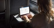 A woman uses a Surface Go on a train