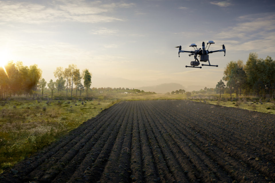 Drone in flight over farm field