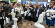 A booth tour group enjoys a robotics demo at Hannover Messe 2019