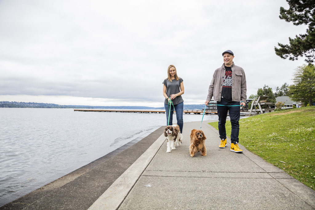 Craig and Melissa Cincotta walk two dogs near a large lake